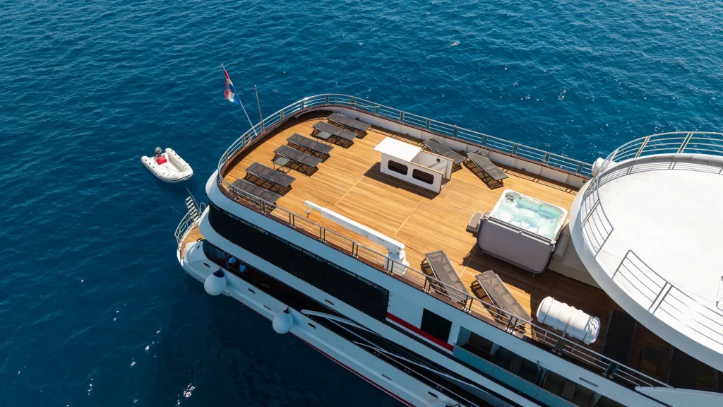 Aerial view of a Zantium small cruise ship sundeck with loungers and hot tub on the Adriatic Sea.